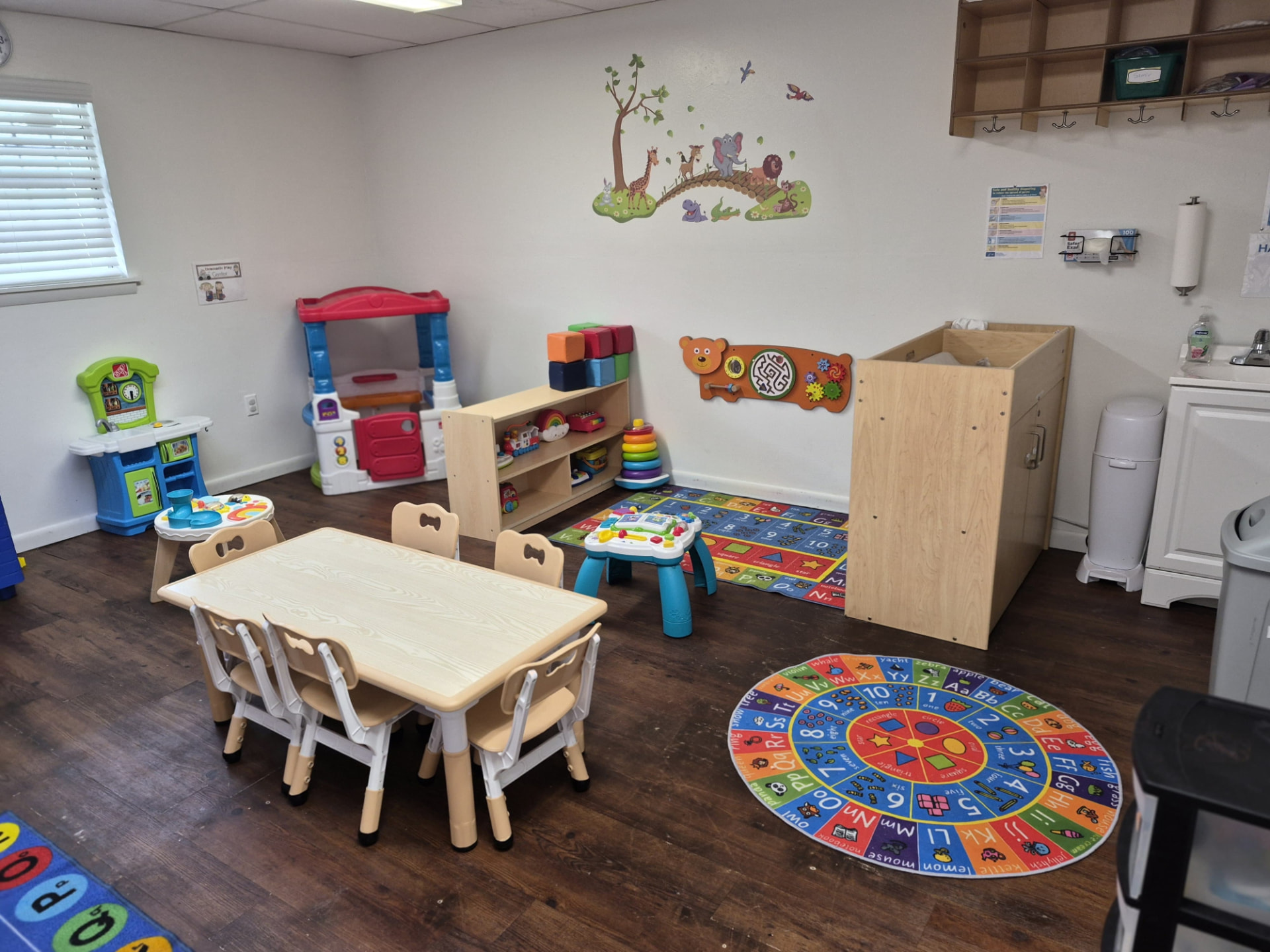 Toddler room with dramatic play kitchen and alphabet rug