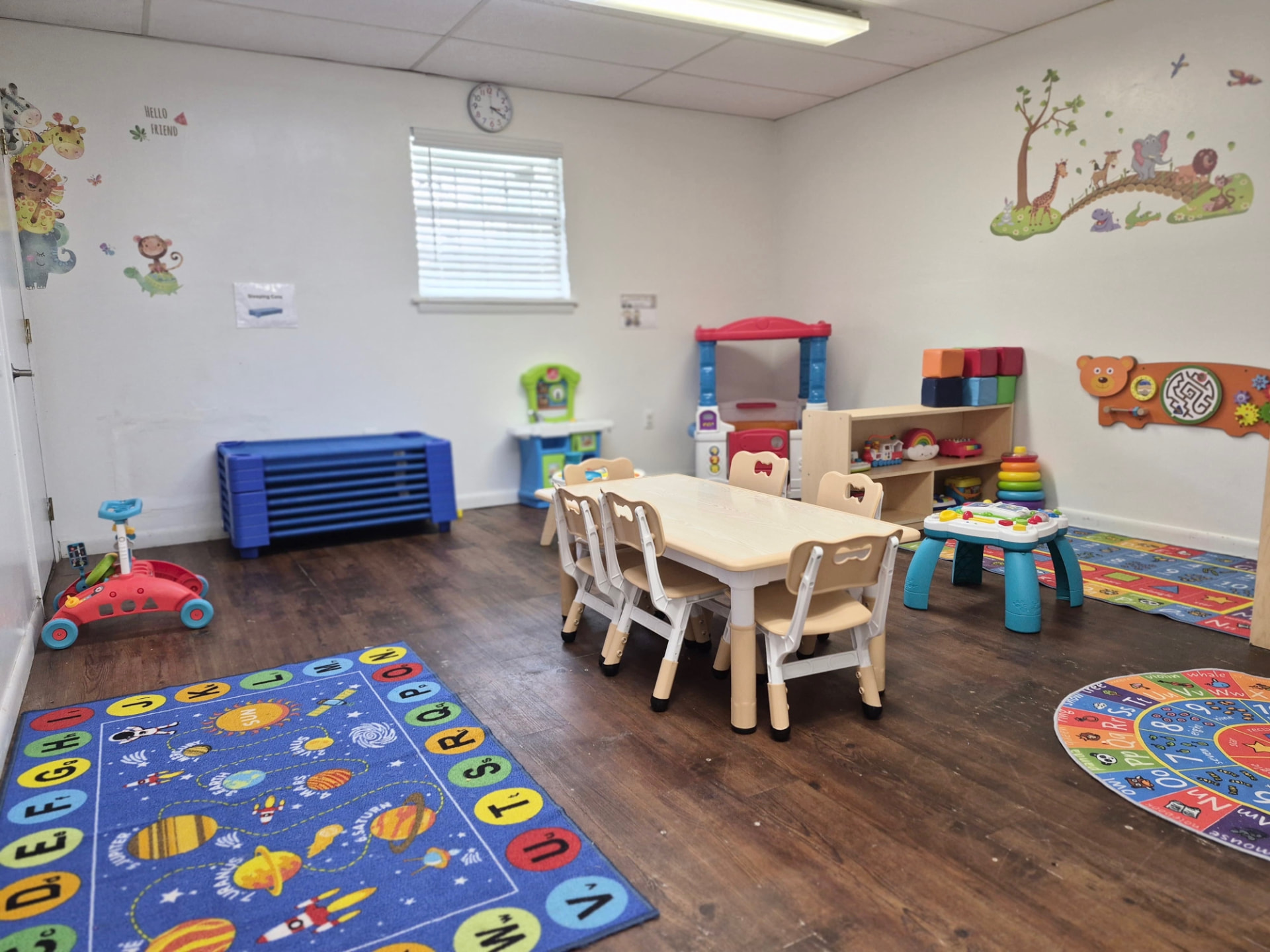 Infant and young toddler room with cots and soft play toys